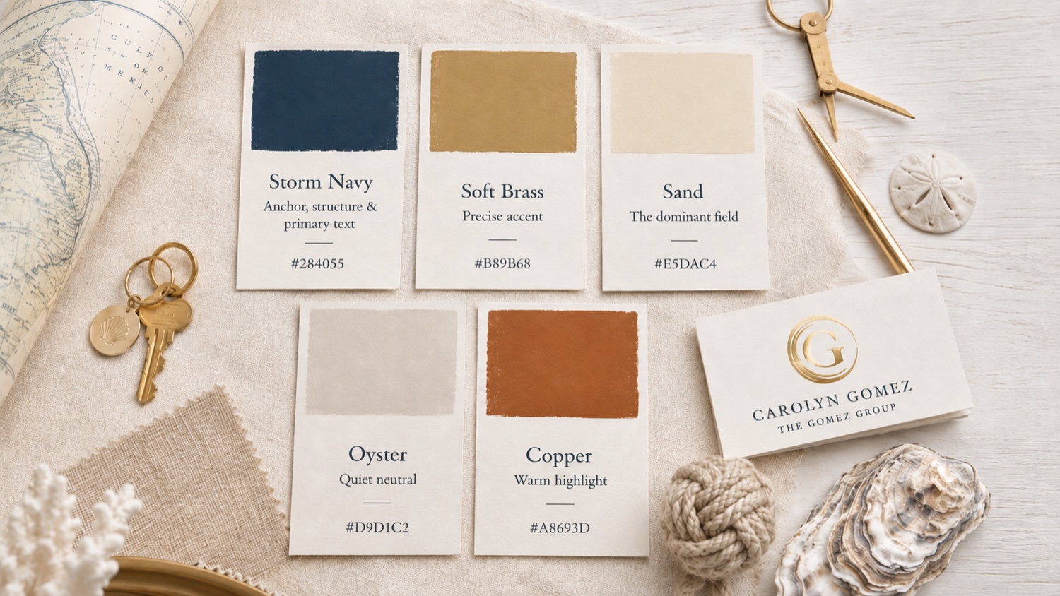 The Gomez Group color palette flat-lay: hand-painted Storm Navy, Soft Brass, Sand, Oyster, and Copper swatch cards with the gold-foil business card, on linen with a Gulf of Mexico map, brass dividers, and shells